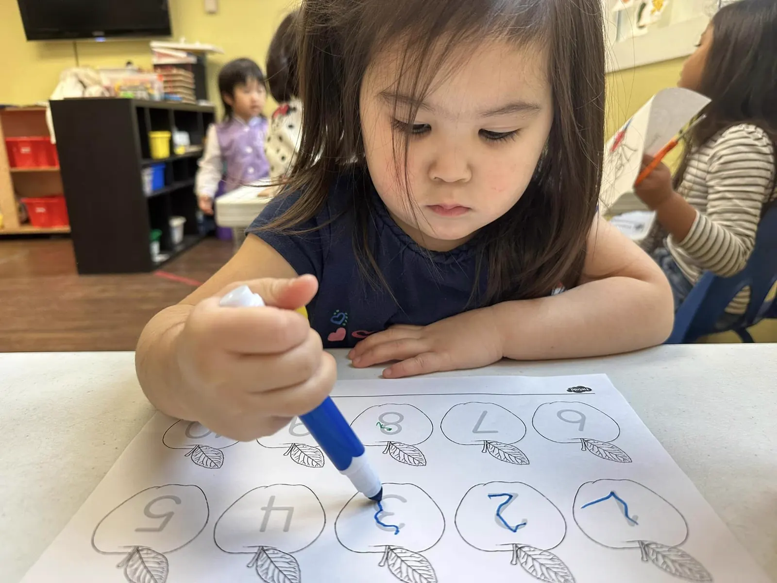 APLS student practicing writing at her desk