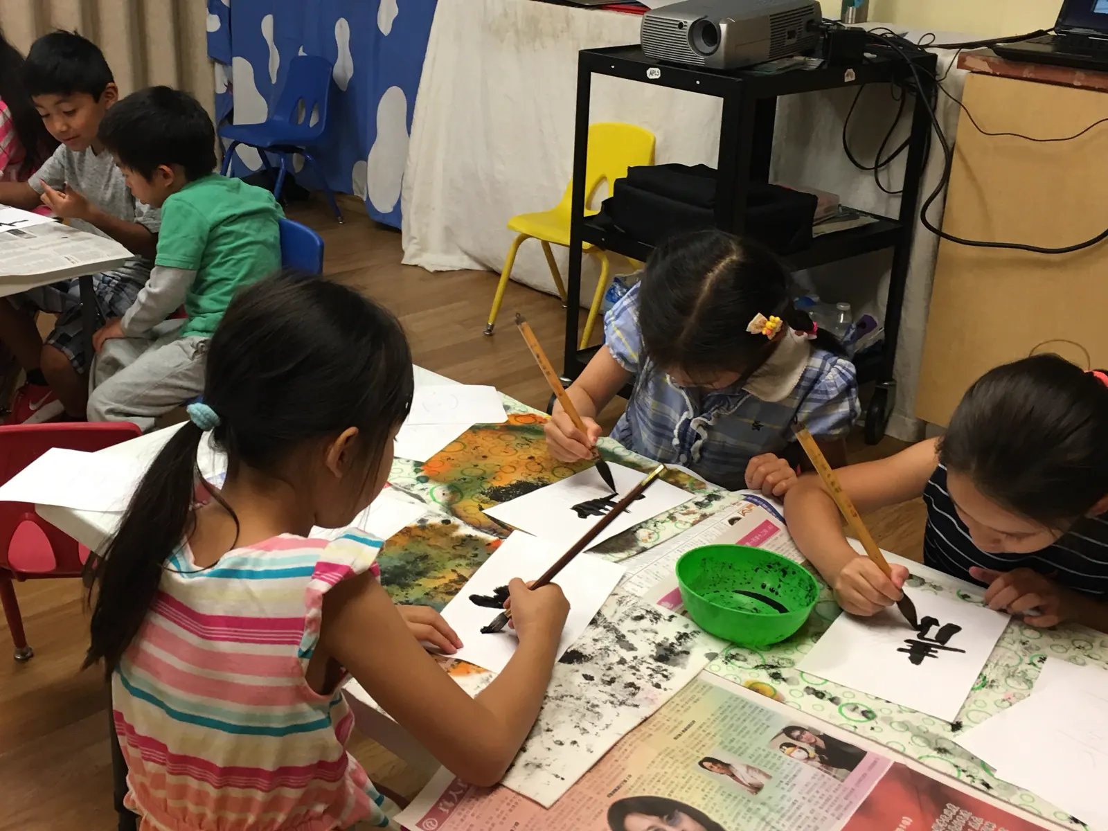 APLS student practicing Chinese and Japanese calligraphy with brush and ink
